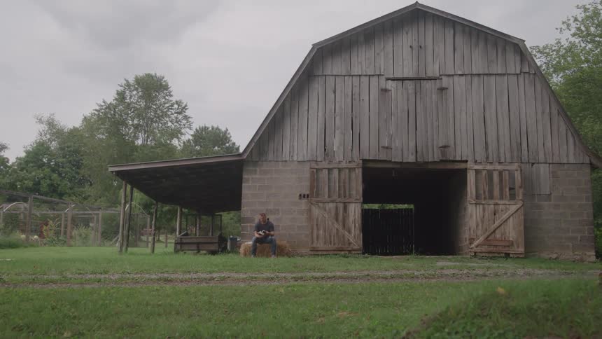Wide view of an old wooden barn on quiet farmland