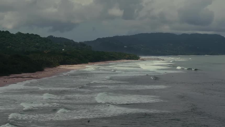 Aerial of waves gently rolling in on a sandy beach