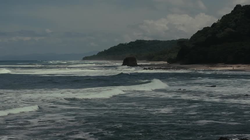The waves are crashing against the foggy shore