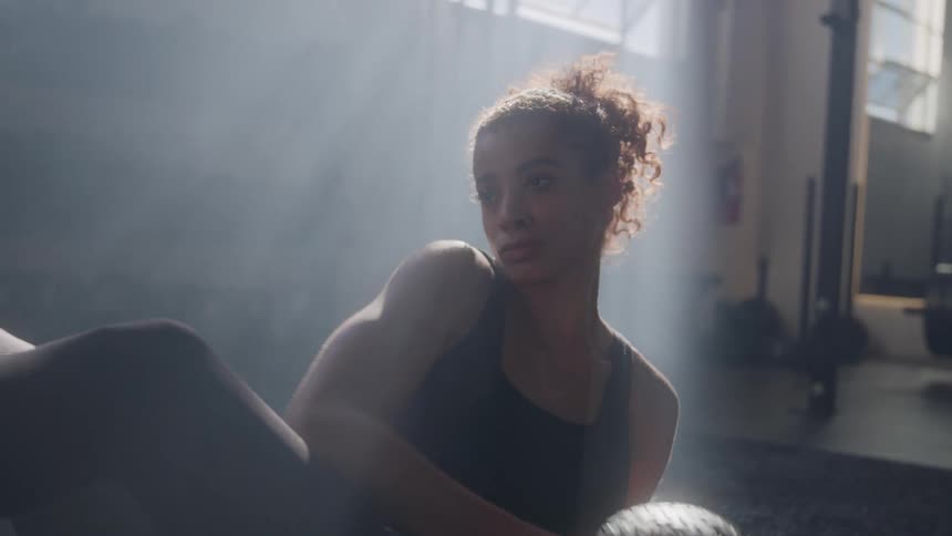 Athlete working out in midset in soft beams of light