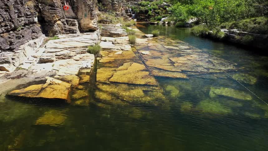 Crystal clear river water flows between rocks and stone formations