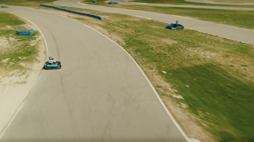 Person driving a gokart at high speed on a winding outdoor track