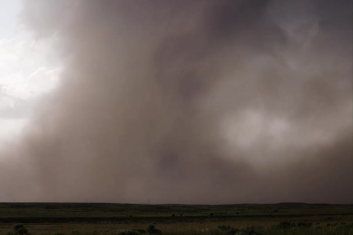 A large and powerful tornado spins as it passes across the landscape