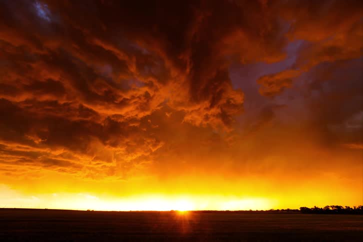 Thunder clouds and lightning in the countryside as the sun rises