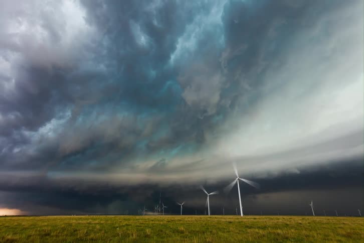 Storm clouds passing and gathering above a windmill farm