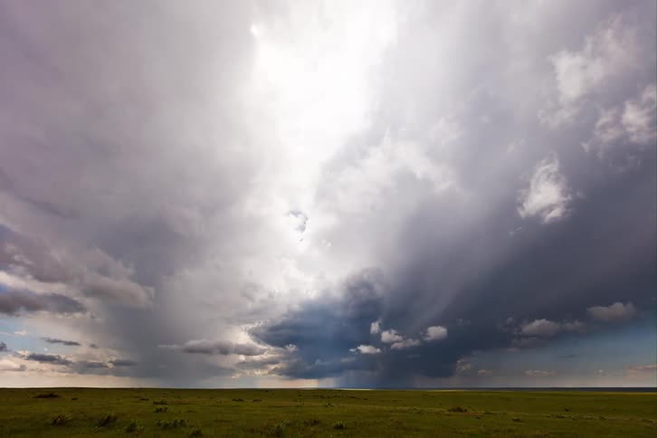 A storm is traveling in the distance on the field