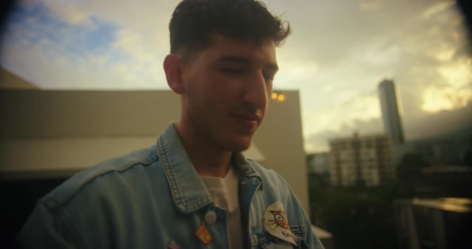 A young man pointing his cell phone forward and taking pictures then turns the cell phone towards him and takes a selfie