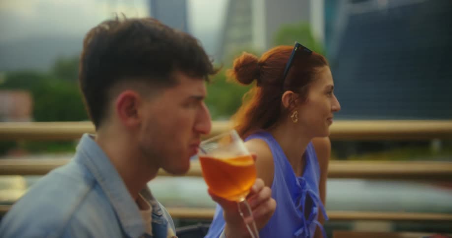 Friends enjoy drinks together on a rooftop outdoors