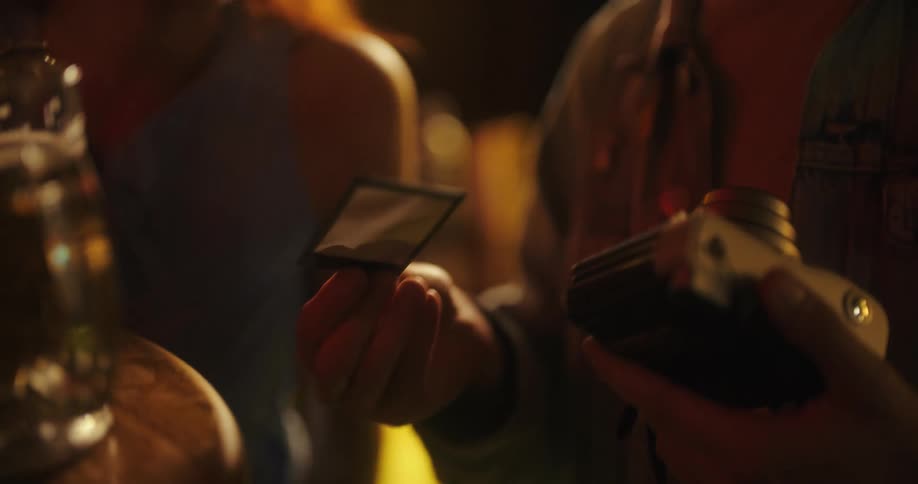 The video shows a group of friends interacting at a lively nighttime event they are seen laughing and clinking glasses of what appear to be cocktails celebrating and enjoying their night together