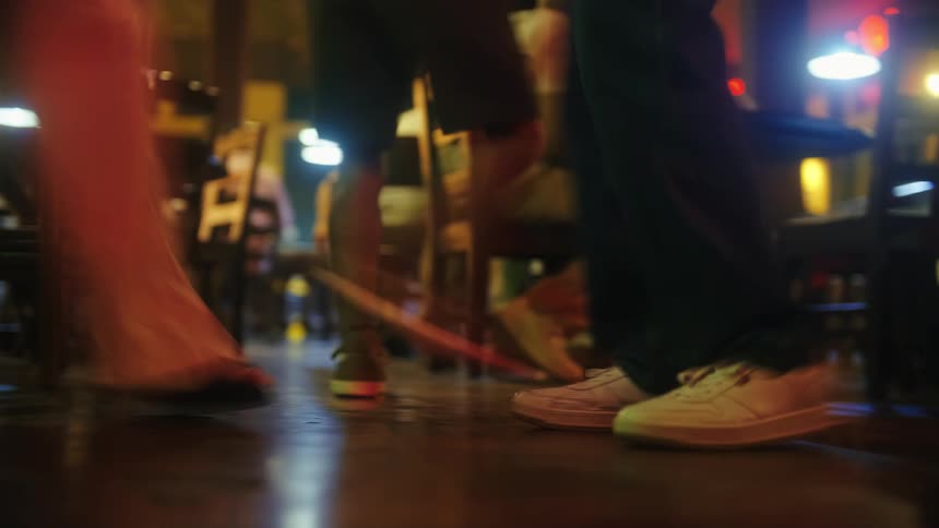 People dance in an environment lit by colorful lights