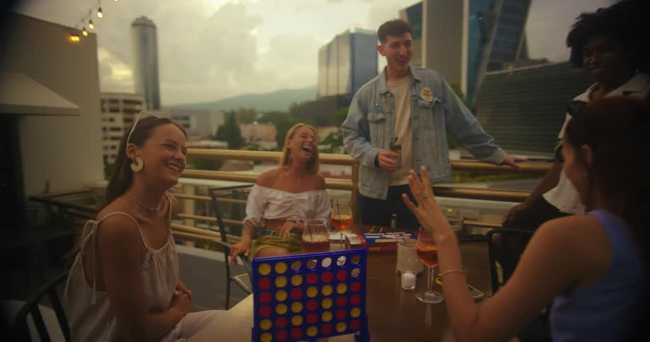 A group of friends are enjoying drinks together on a rooftop terrace