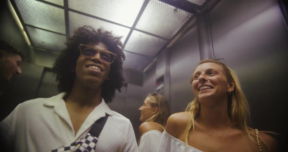 Friends talk while riding the elevator