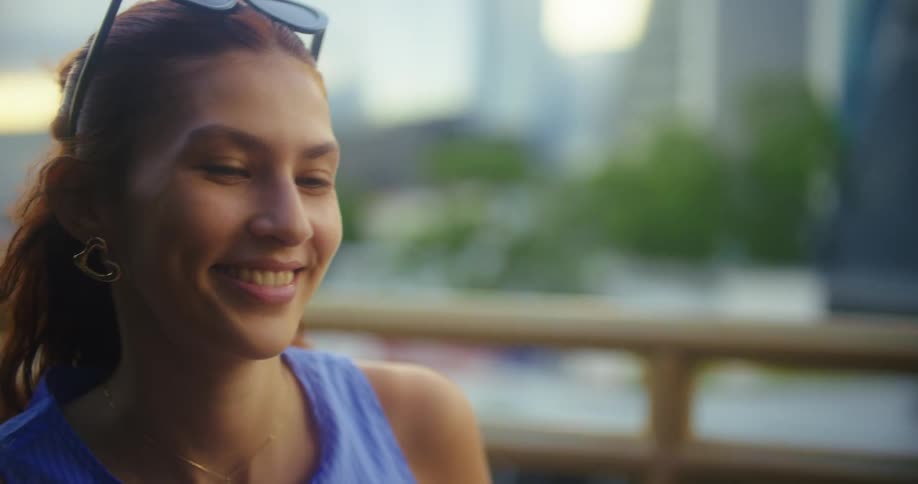 The woman smiles and talks outside