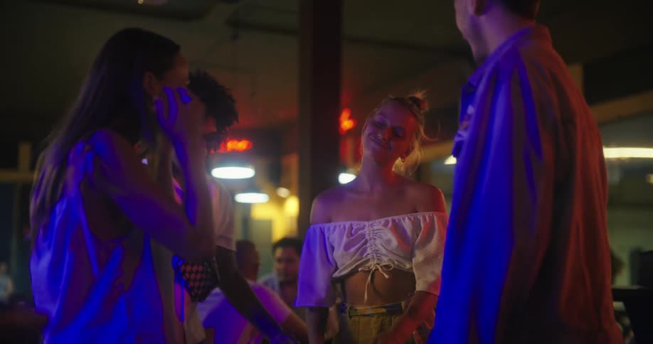 A group of friends dancing and having fun in a night club at night