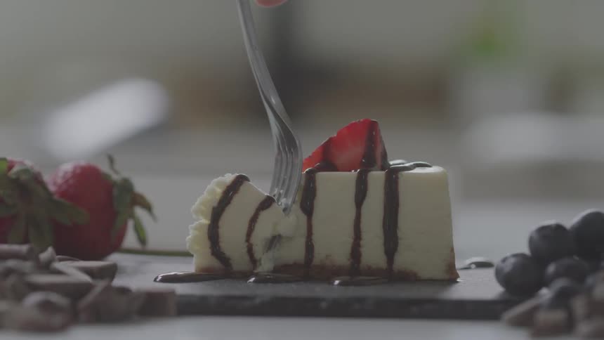 A slice of cake topped with strawberry and chocolate