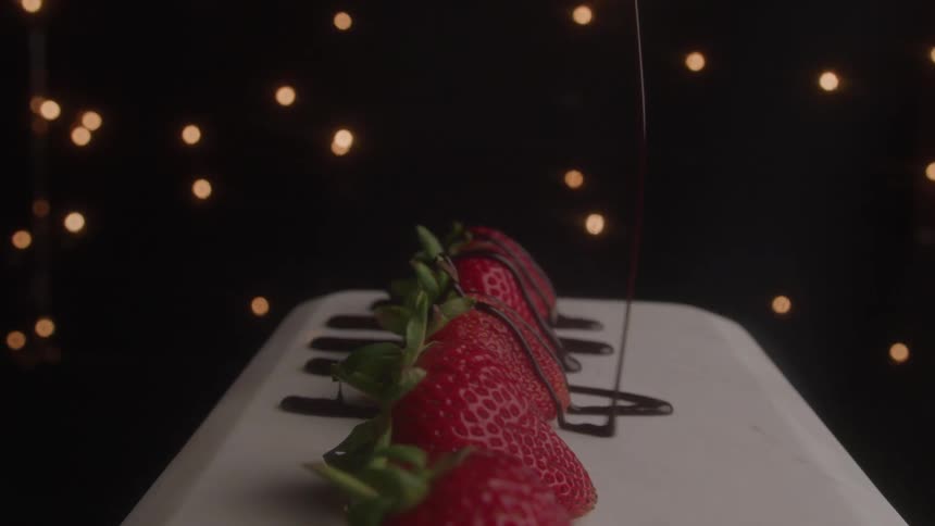 Chocolate is drizzled on the strawberries