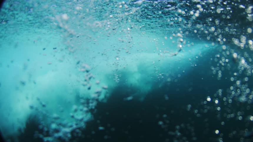 Bubbles float around underwater after the wave crashes