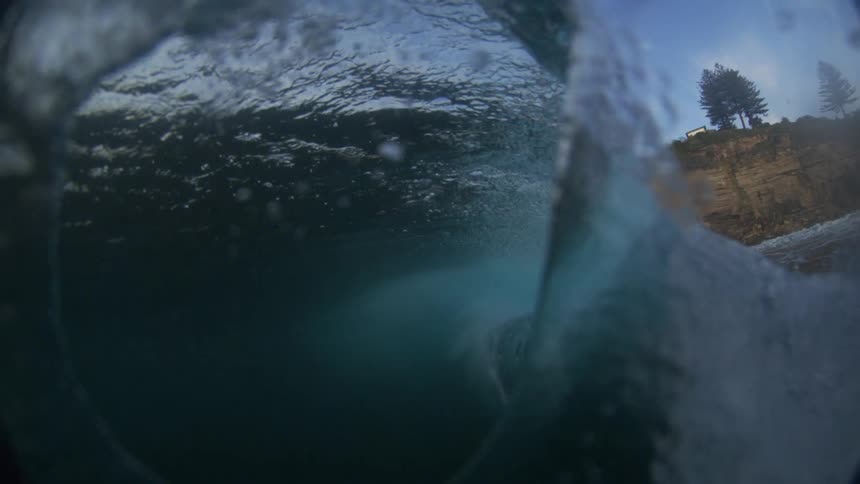 Huge wave splashes as it rolls into shore and the view goes underwater