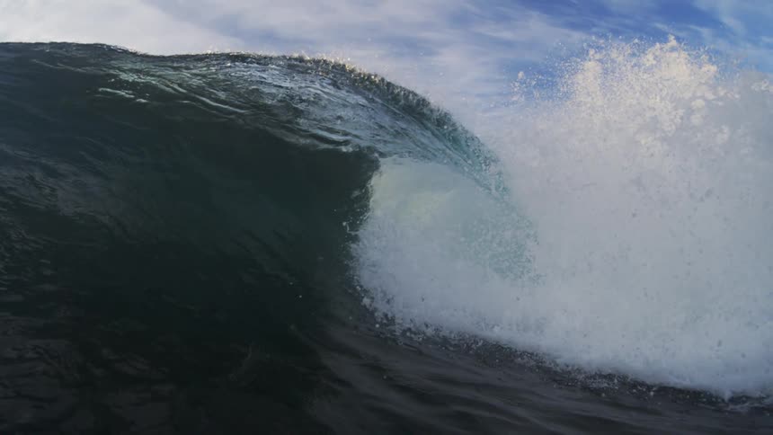 A large ocean wave builds up and then comes crashing down