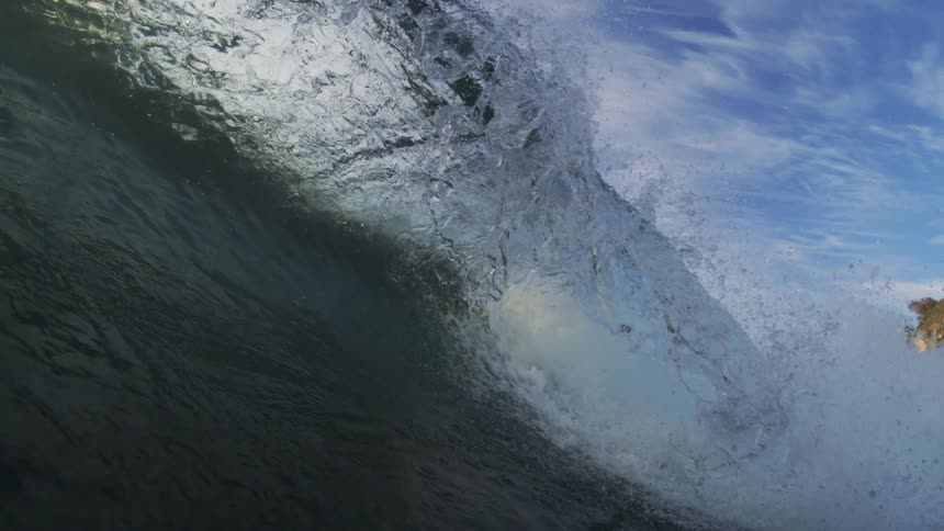 Wave curls and splashes overhead as it rolls into shore and the view goes underwater