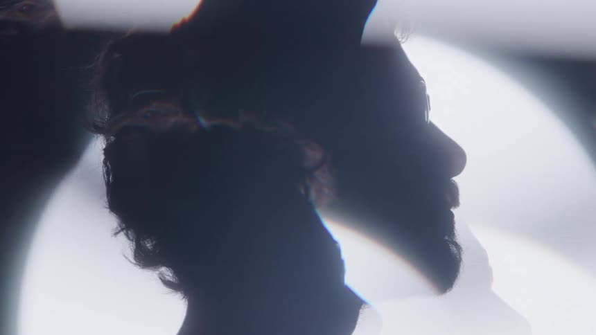 A silhouetted person with bright glowing lights in the background