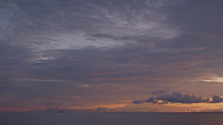 At sunset the sky is filled with clouds above the open ocean