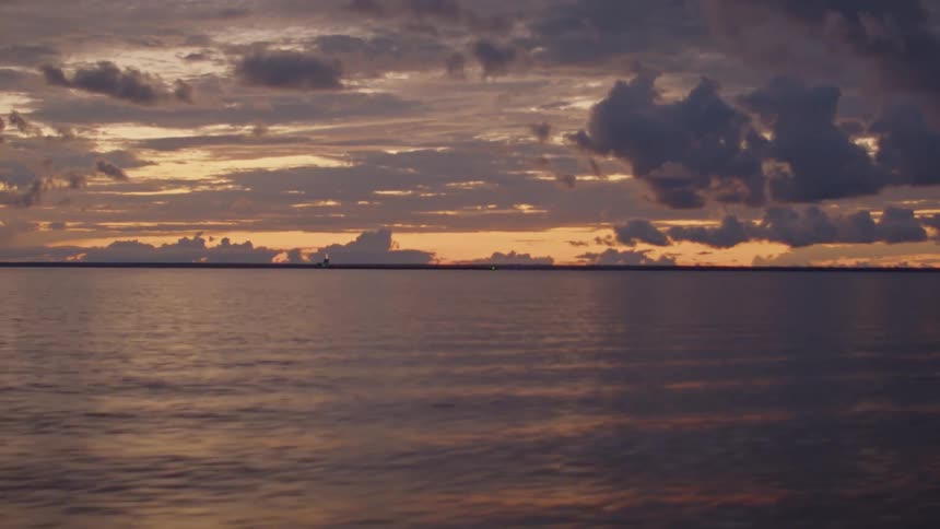 The sun is rising on the shore