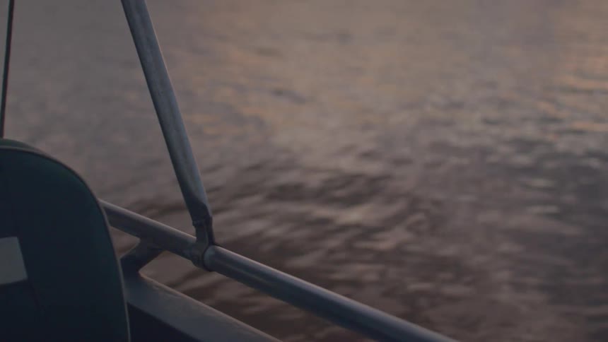 Boat seat appears in the foreground with the river in the background