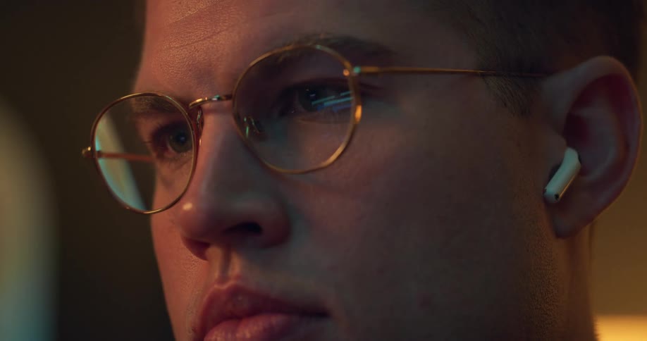 White man wearing glasses indoors with a computer screen reflected on the glasses