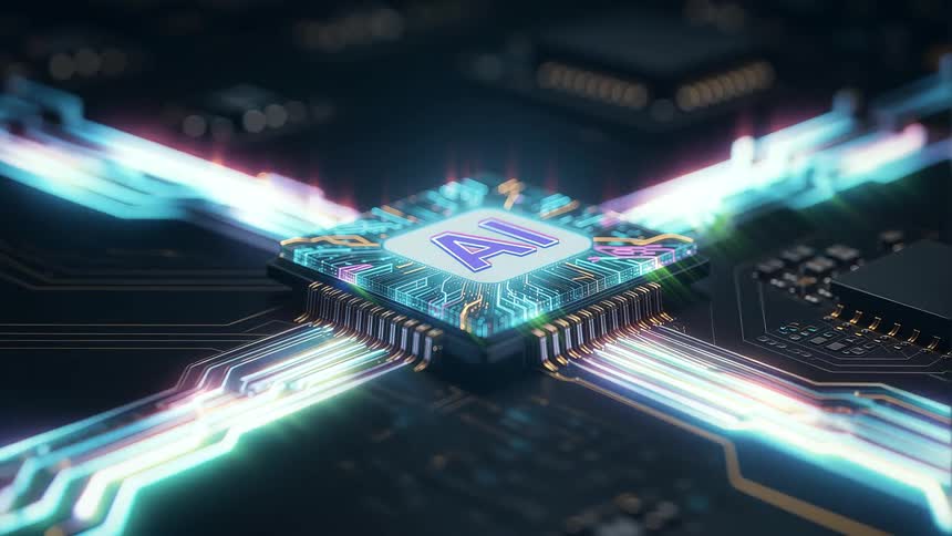 A close view shows a glowing blue and orange microchip surrounded by glowing light beams and gold circuitry on a dark computer board