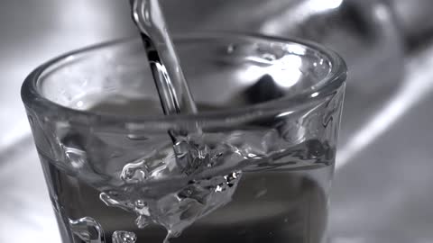 Close up of a transparent liquid poured into a small glass cup