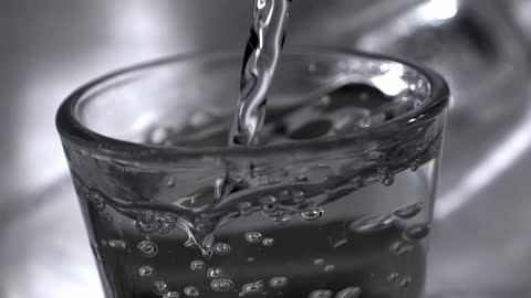 Stream of clear water fills a glass