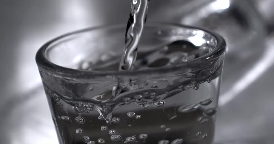 Stream of clear water fills a glass