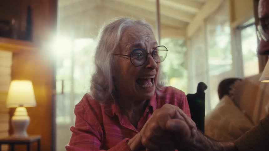 The woman smiles while doing a jigsaw puzzle with a man