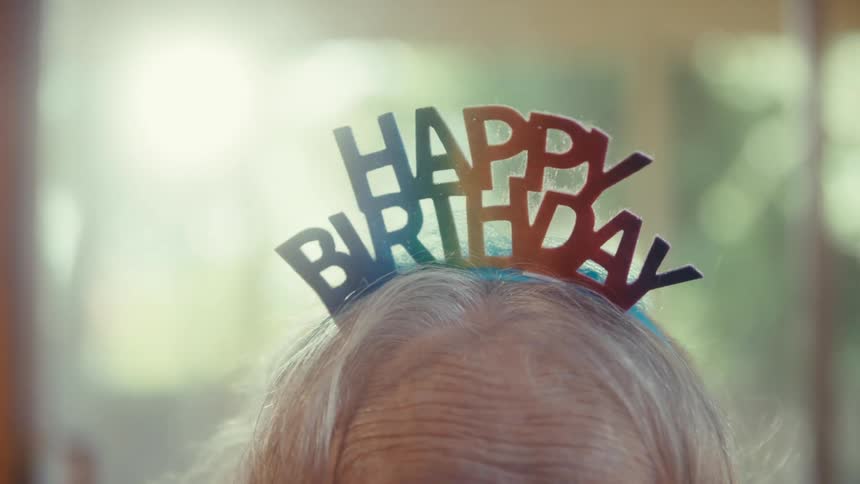 Colorful headband with the phrase happy birthday on gray hair