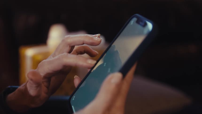 A person scrolls on a smartphone using both hands