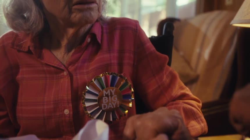 Elderly couple holding hands with lady with gift box