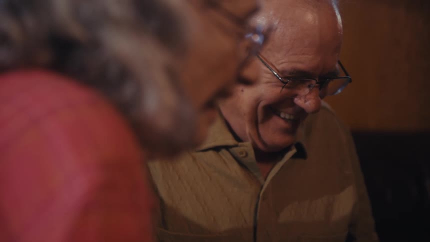 Elderly couple smiles in a lighthearted moment side by side