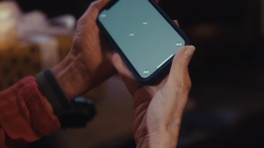 Close up of an elderly woman watching media content on a mobile phone in her hands