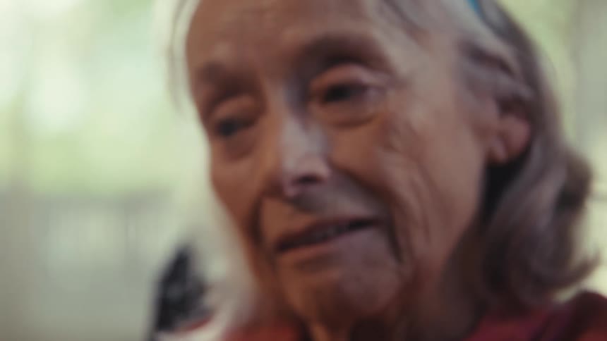 Close up of an elderly woman on a video call with a mobile phone while sitting in a living room during daytime