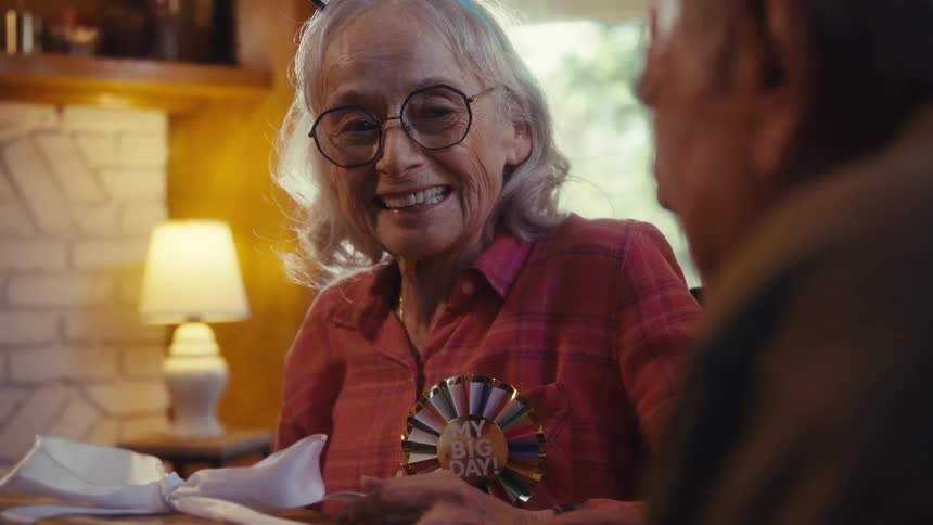 A woman smiles as she holds her birthday gift