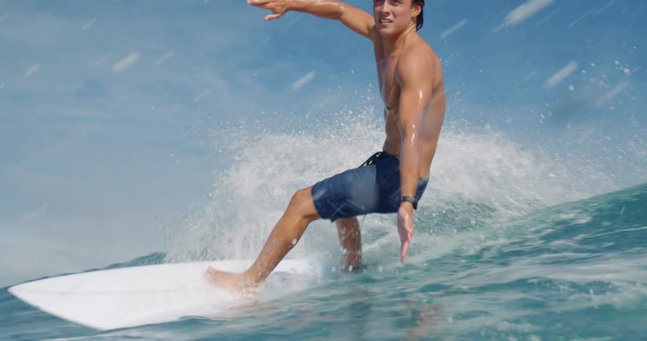 Surfer rides a big wave and water splashes as he turns then the view goes underwater