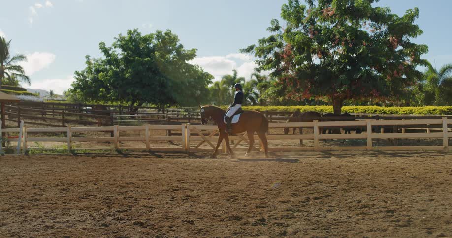 Woman rides a horse in the corral on a cloudy day