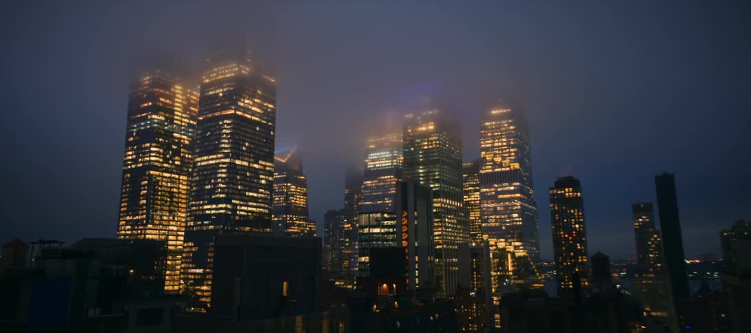 Skyscrapers glow through the fog in the city at night