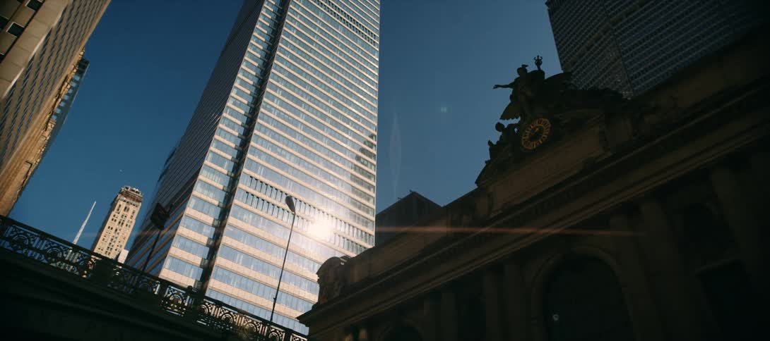 Tall skyscrapers and a historic building rise under clear daylight