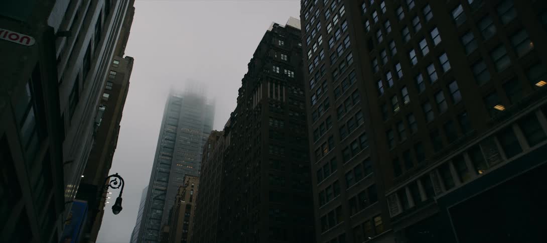 The tallest skyscraper that towers above others is engulfed in fog