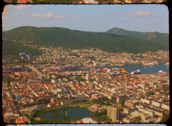 Aerial view of a city surrounded by mountains and coastal area