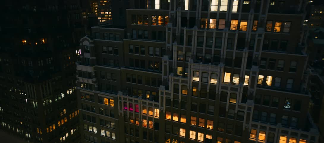Facade of a tall building lit by interior lights at night