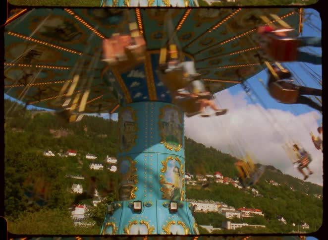 A group of people riding a swing ride in an amusement park at midday