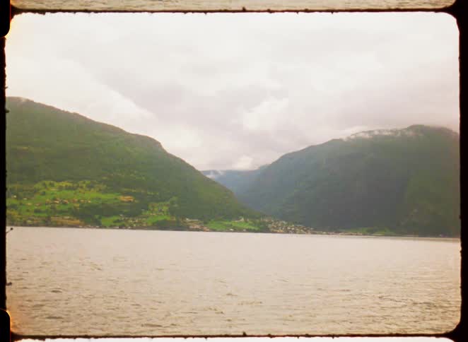 A fjord or lake in a mountainous region with a coastal town along its shore